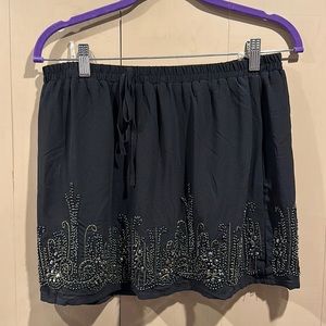 Black skirt with beaded detailing.